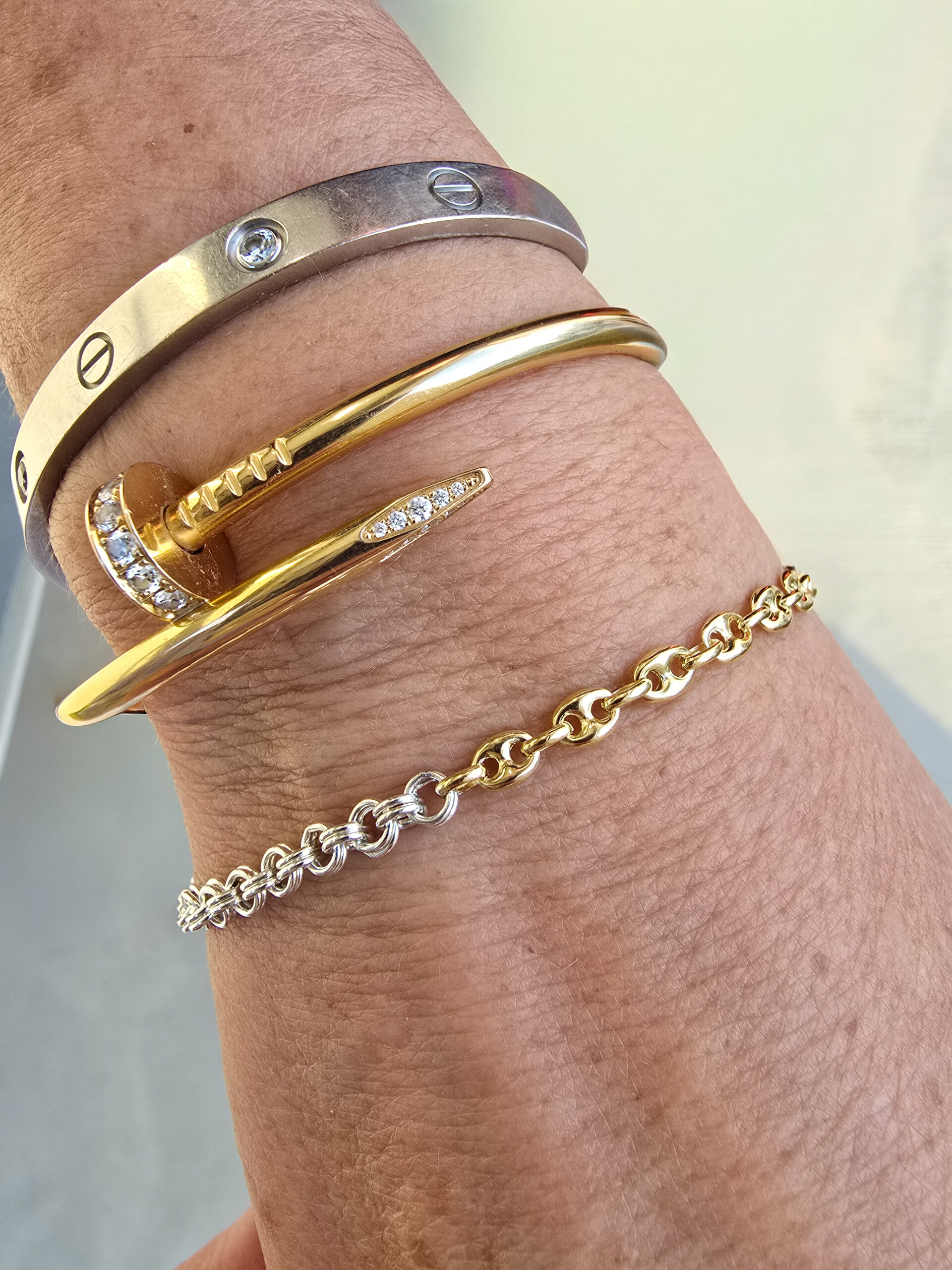 Permanent jewelry stack featuring 14k gold and sterling silver bracelets on wrist — KWB Permanent Jewelry Utah.